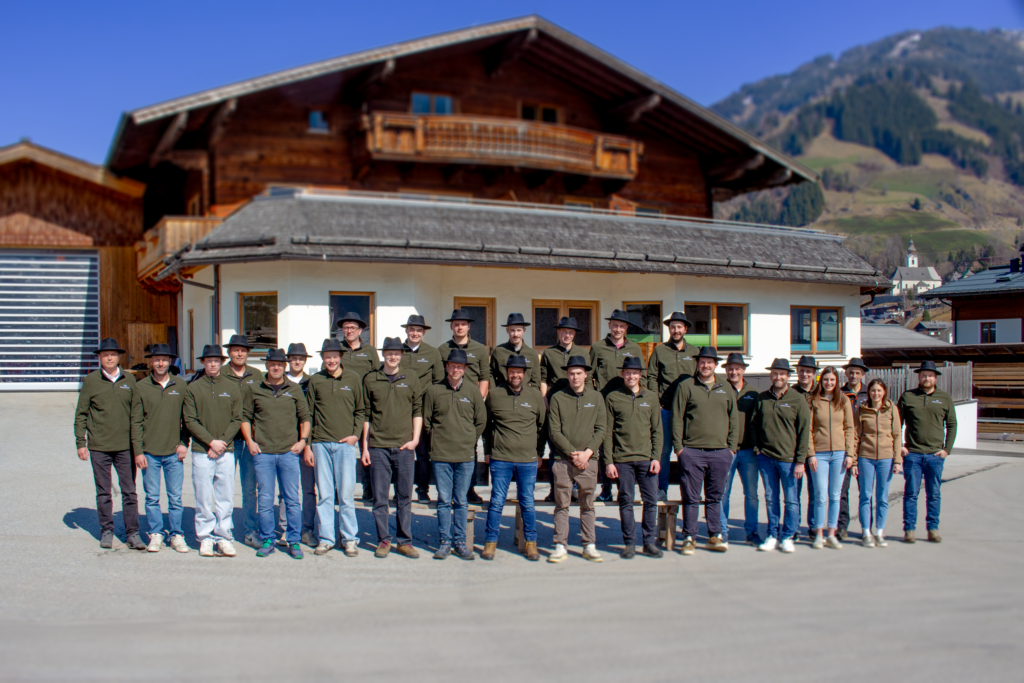 Team von Holzbau Gruber mit vielen Männern und Frauen in Grünen Pullovern